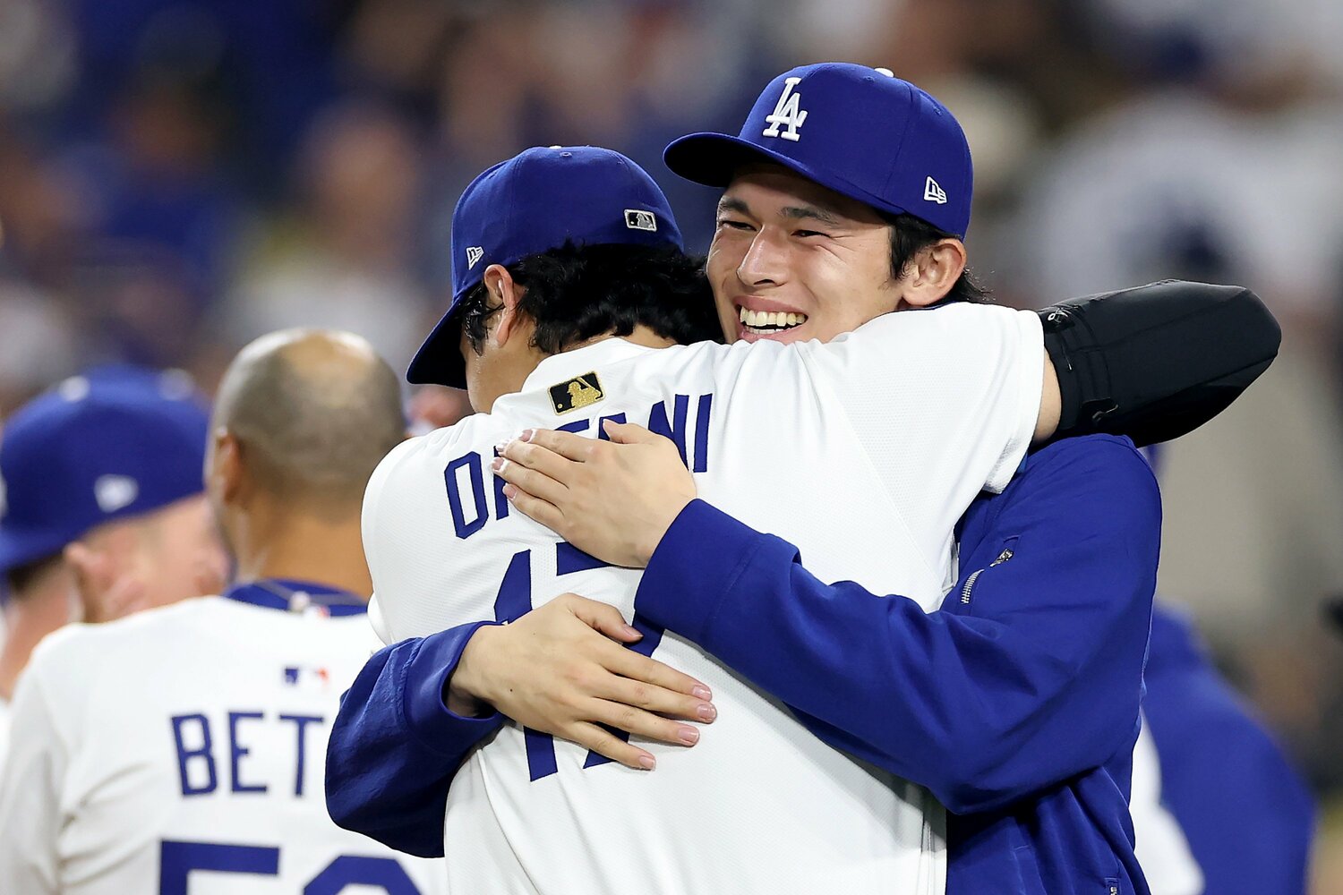 写真はワールドシリーズ、ブルージェイズとの第3戦。延長18回サヨナラ勝ちの直後、大谷翔平と抱き合う佐々木 ©Getty Images