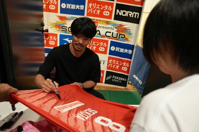 自身のユニフォームにサインする関田誠大