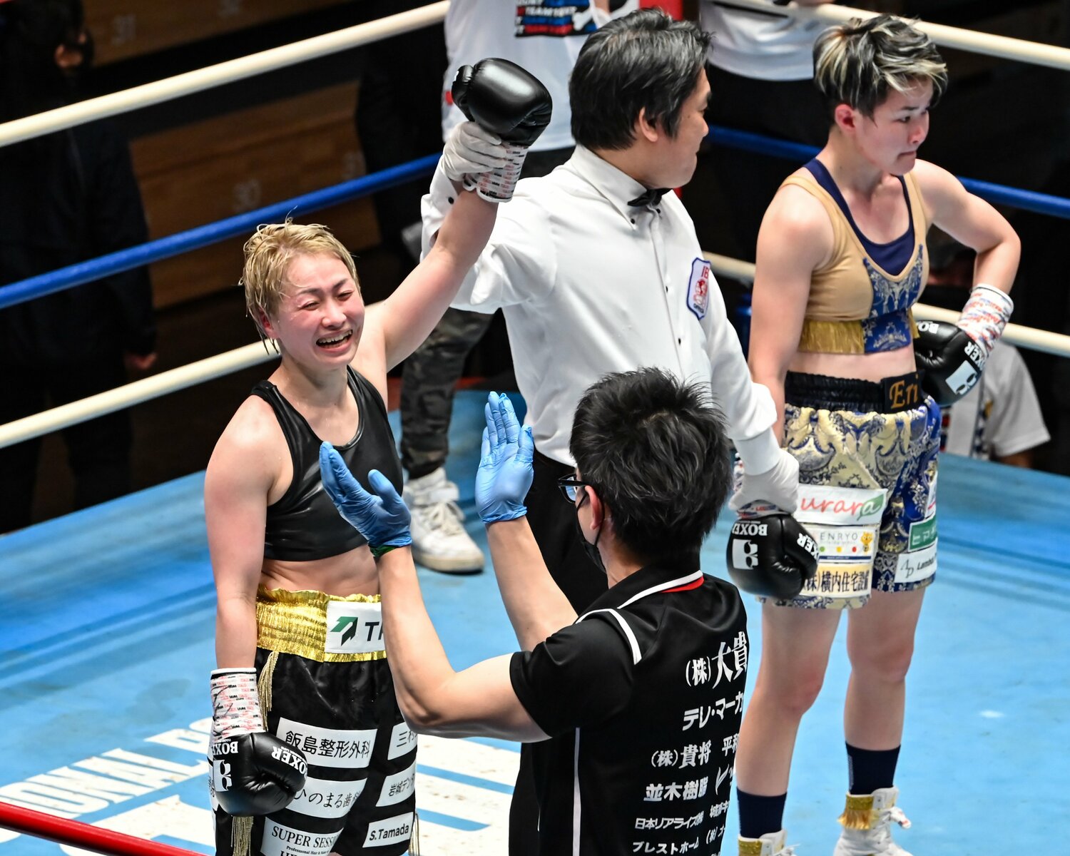 2022年2月、チャンピオンベルトをつかみ取り、トレーナーに喜びの表情を見せる宮尾　©Hiroaki Finito Yamaguchi/AFLO