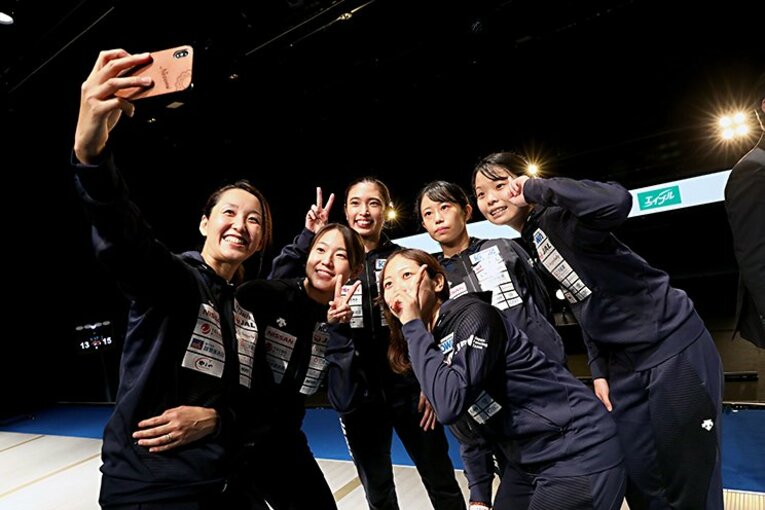 試合後、選手たちとスマホで写真を撮影する佐藤（手前） ／ photograph by Japan Fencing Federation