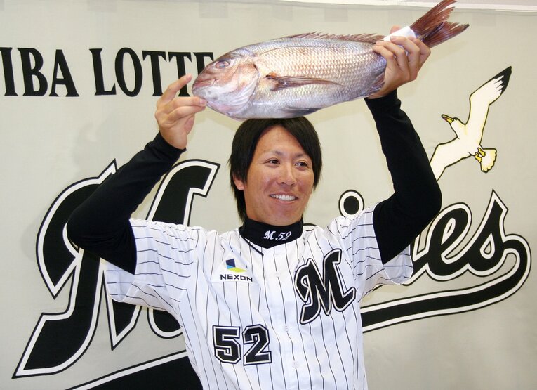 パ・リーグ新人王に輝き、タイを掲げて喜ぶロッテ益田直也。プロ1年目の2012年は72試合に登板し、2勝2敗41ホールド1セーブ・防御率1.67を記録した　©︎JIJI PRESS