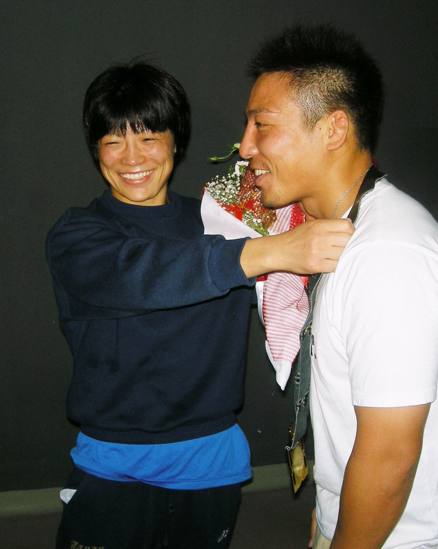 夫の康司さんに世界選手権金メダルをかける小原さん(2011年) ©JIJI PRESS