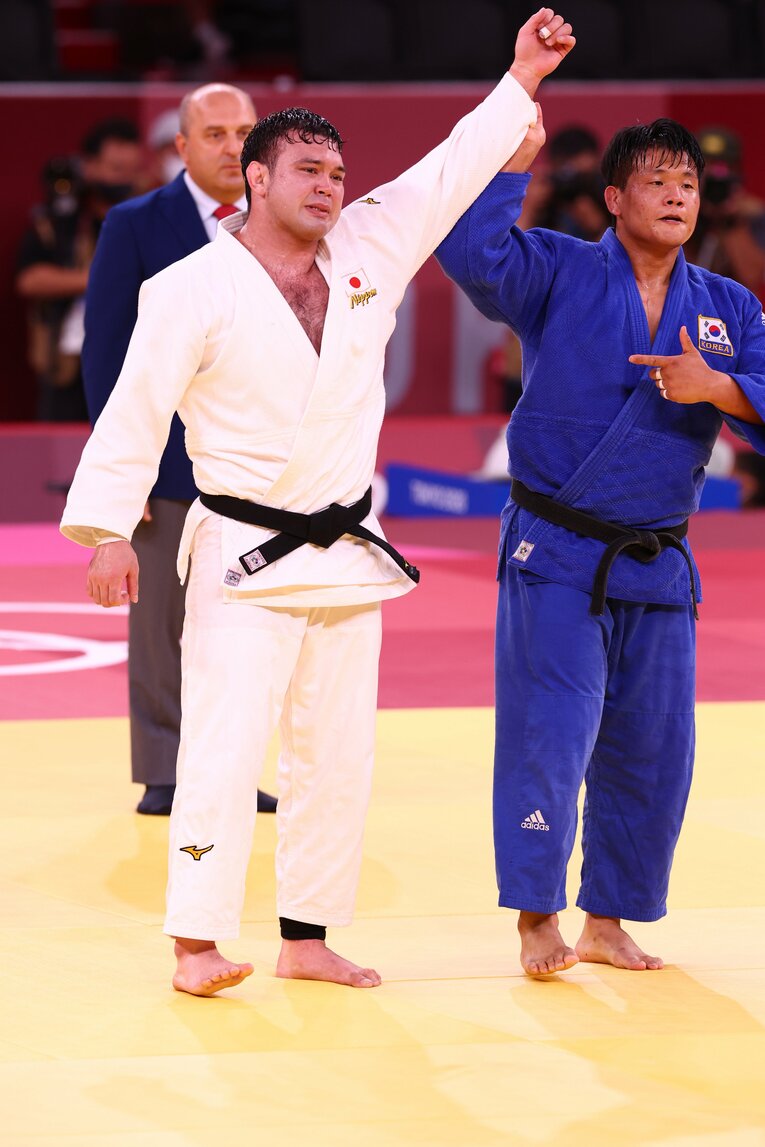 死闘の後、ウルフの手を取り高々と上にあげるチョ・グハム　©JMPA