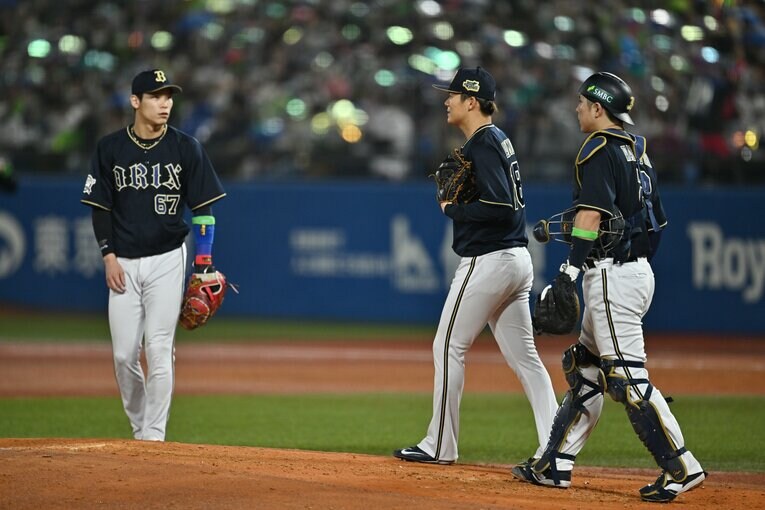 マウンドの山本のもとに集まる捕手の若月健矢と一塁手の中川圭太　©︎Hideki Sugiyama