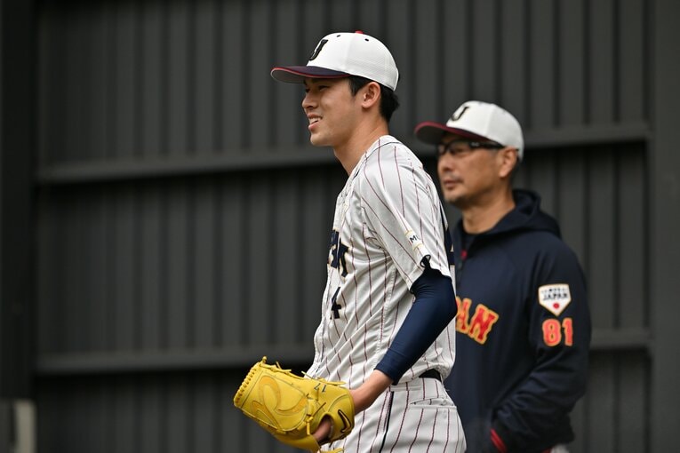 吉井コーチに見守れながら投球練習に臨む佐々木　©︎Hideki Sugiyama