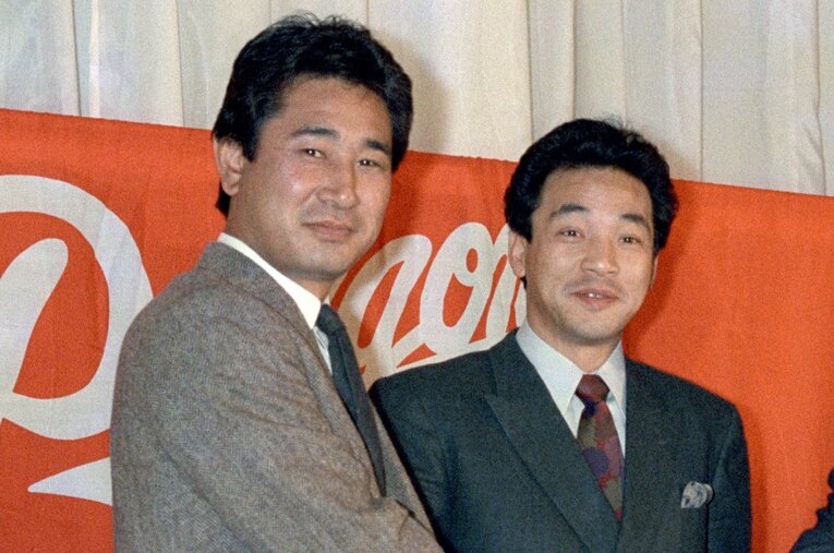 1986年12月26日、中日入団発表で星野監督（当時39歳）と握手する落合博満（33歳） ／ photograph by KYODO