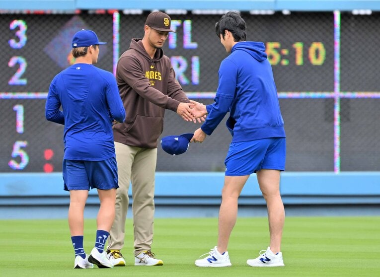 直接対決の前日に握手を交わす2人。大谷の表情は…　©JIJI PRESS