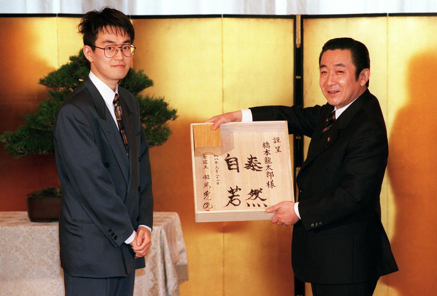 内閣総理大臣顕彰を受けた羽生（左）が、橋本龍太郎首相（当時）にサイン入りの将棋盤を贈る　©JIJI PRESS