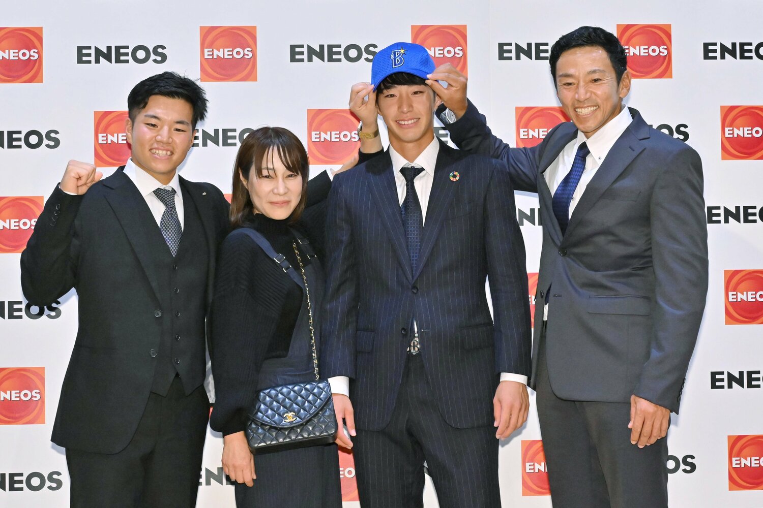 ベイスターズから指名を受けた次男・隆輝に帽子をかぶせる度会さん　©︎JIJI PRESS