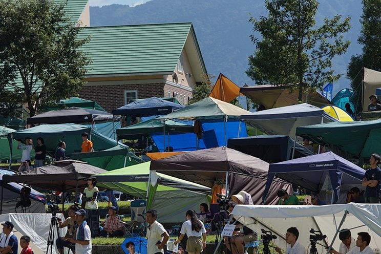 観客席に並ぶテントやタープは、選手や引率者の観戦するために加え、選手たちがフィジカルケアを受けるスペースにもなっている。