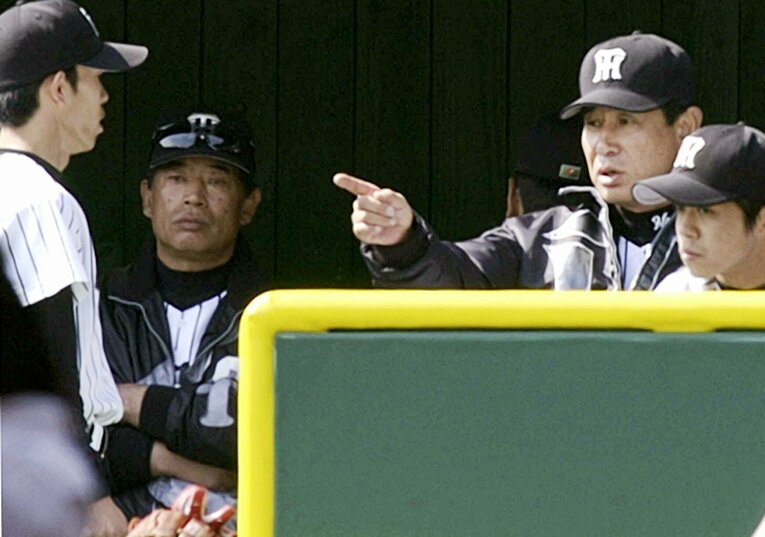 2002年3月オープン戦、厳しい表情で赤星に指示を出す星野監督　©JIJI PRESS