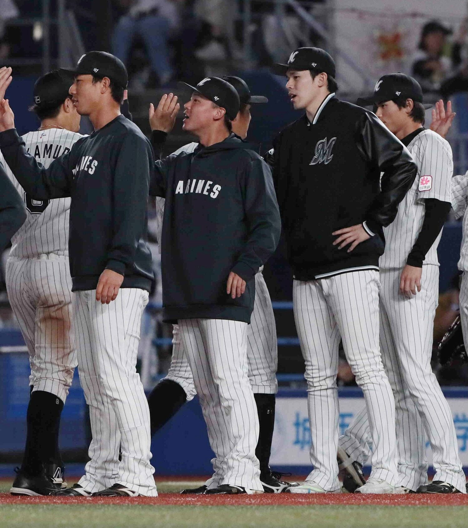 初戦に勝利し、ハイタッチの列に加わる先発の佐々木朗希(右から2人目)ら ©︎JIJI PRESS