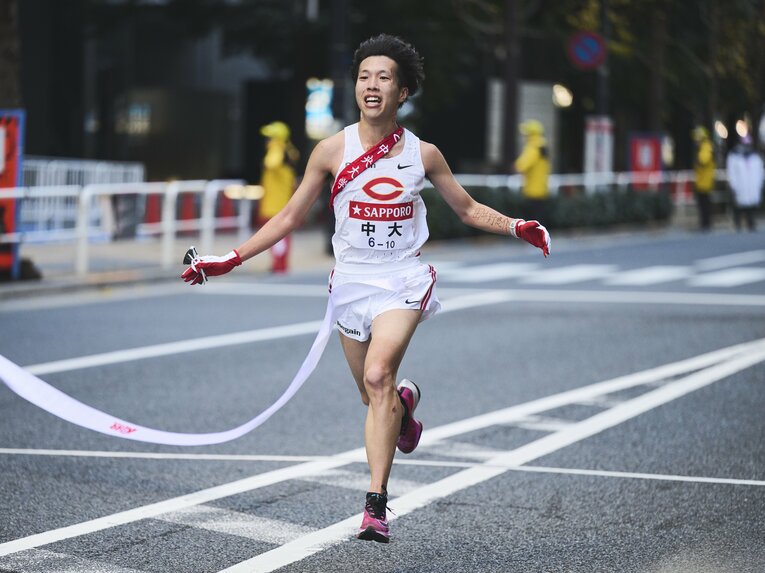 ゴール時の助川。左腕には同じ4年生で箱根を走ることができなかったライバルの名前があった　※スクロールすると左腕の文字にズームした写真がご覧になれます　©Yuki Suenaga