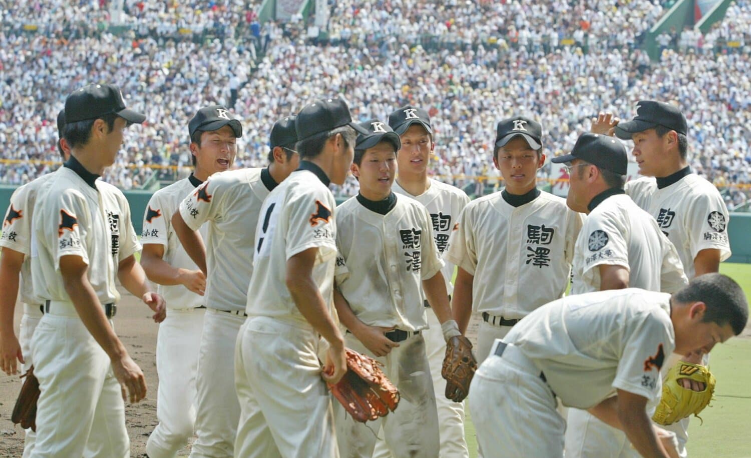 香田監督(右から2人目)の指示を聞く駒大苫小牧ナイン。2006年夏の甲子園、早実との決勝再試合で ©JIJI PRESS