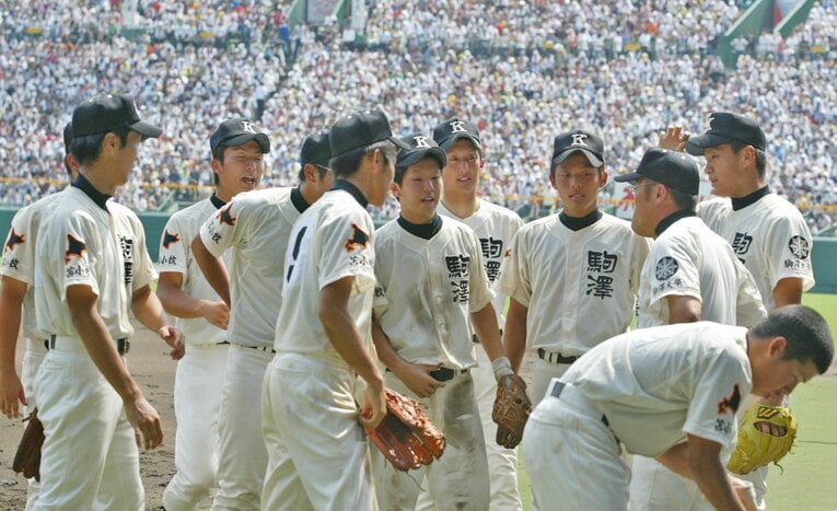 香田監督（右から2人目）の指示を聞く駒大苫小牧ナイン。2006年夏の甲子園、早実との決勝再試合で　©JIJI PRESS