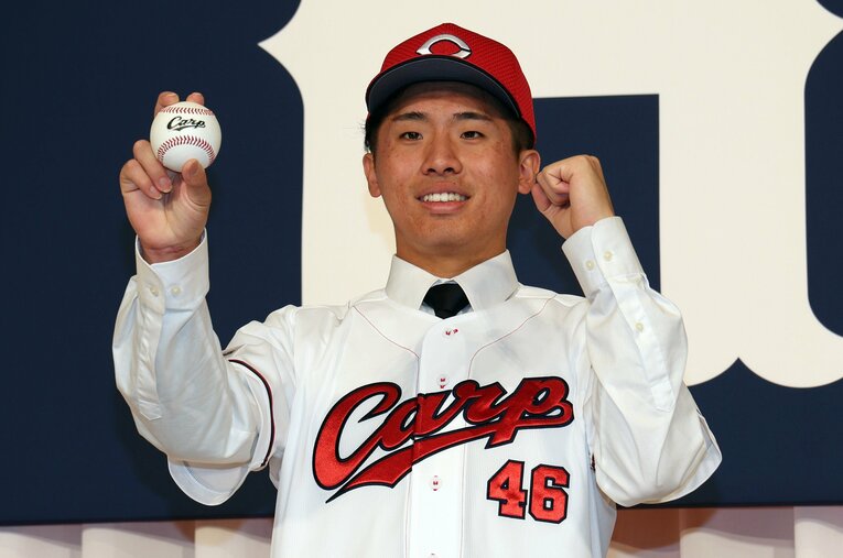 入団会見の撮影でポースをとる高木。背番号は46をつける ／ photograph by JIJ PRESS