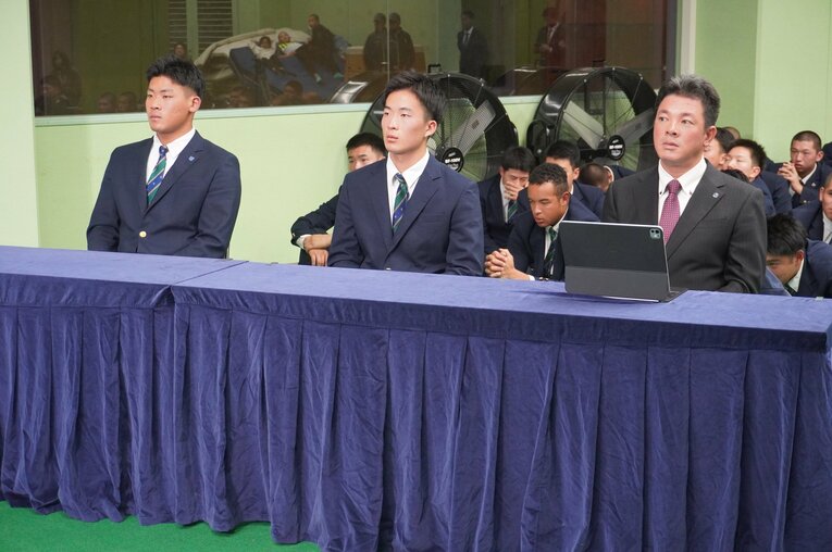 10月23日、仙台育英高校。ドラフト会議のテレビ中継を見つめる須江航監督。プロ野球志望届を提出していた3年生の高田庵冬（左）と吉川陽大（中央）。後ろでは野球部員が祈るように手を合わせる　©Kei Nakamura