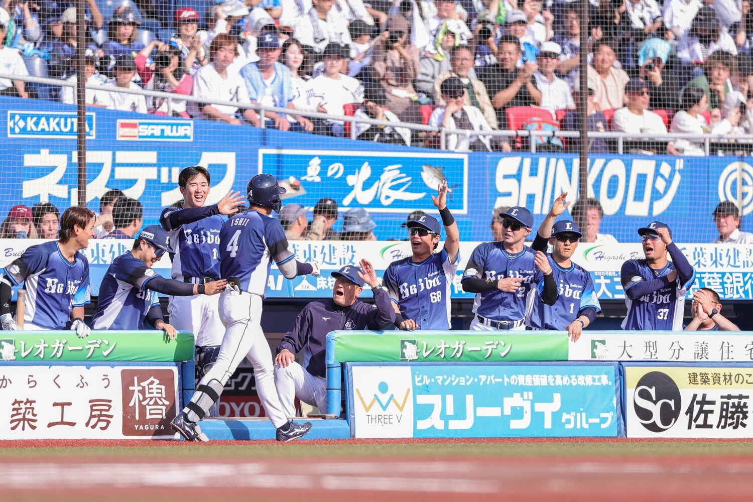 1号アーチを放ちチームメートの出迎えを受ける石井 ©JIJI PRESS