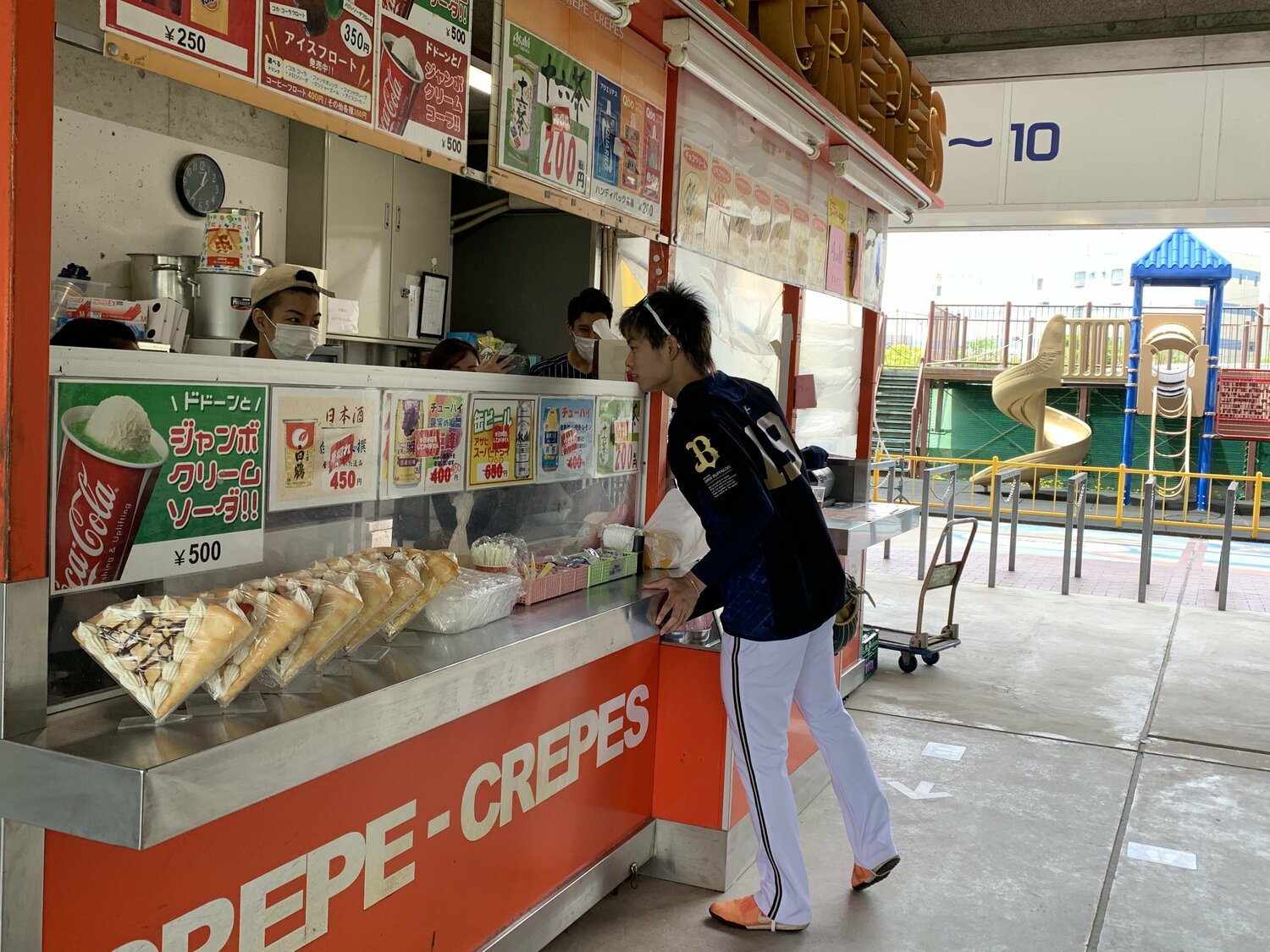 今年5月、チームメイトに差し入れするためにクレープを購入する山岡 ©︎Noriko Yonemushi