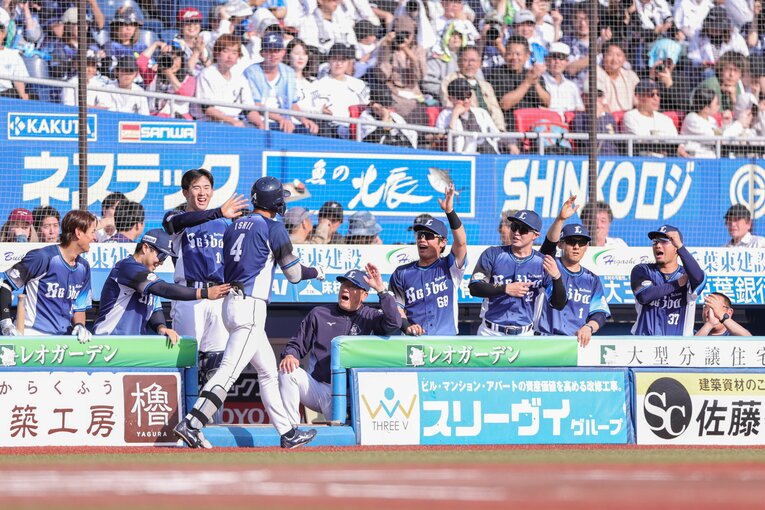 1号アーチを放ちチームメートの出迎えを受ける石井　©JIJI PRESS