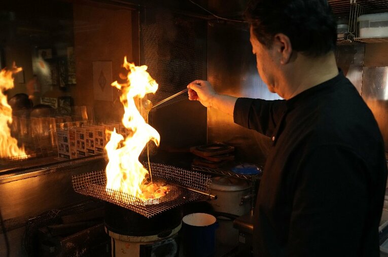 アントニオ猪木が好んだ『鳥亭』のもも炭火コロ焼き。客席からも豪快な炎のパフォーマンスを見ることができる ／ photograph by Essei Hara