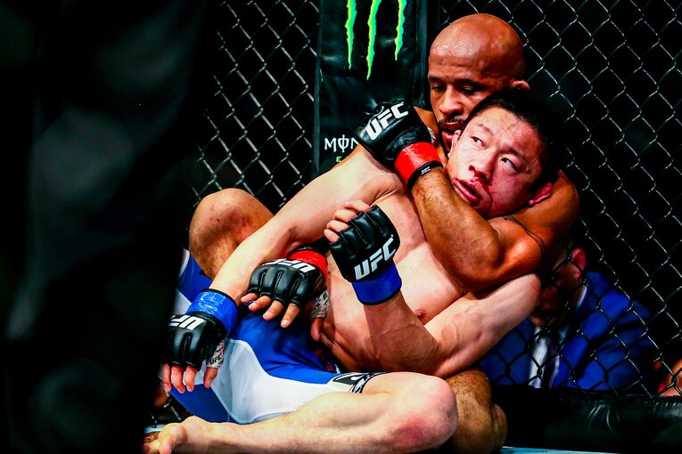 流血する堀口恭司を背後から攻めるデメトリアス・ジョンソン　©Susumu Nagao