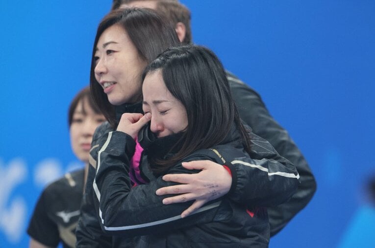 20日の決勝戦後、藤澤五月の肩を抱く石崎琴美。フィフス（リザーブ）としてロコ・ソラーレの快進撃を支え、冬季五輪の日本人最年長メダリストとなった ／ photograph by JMPA