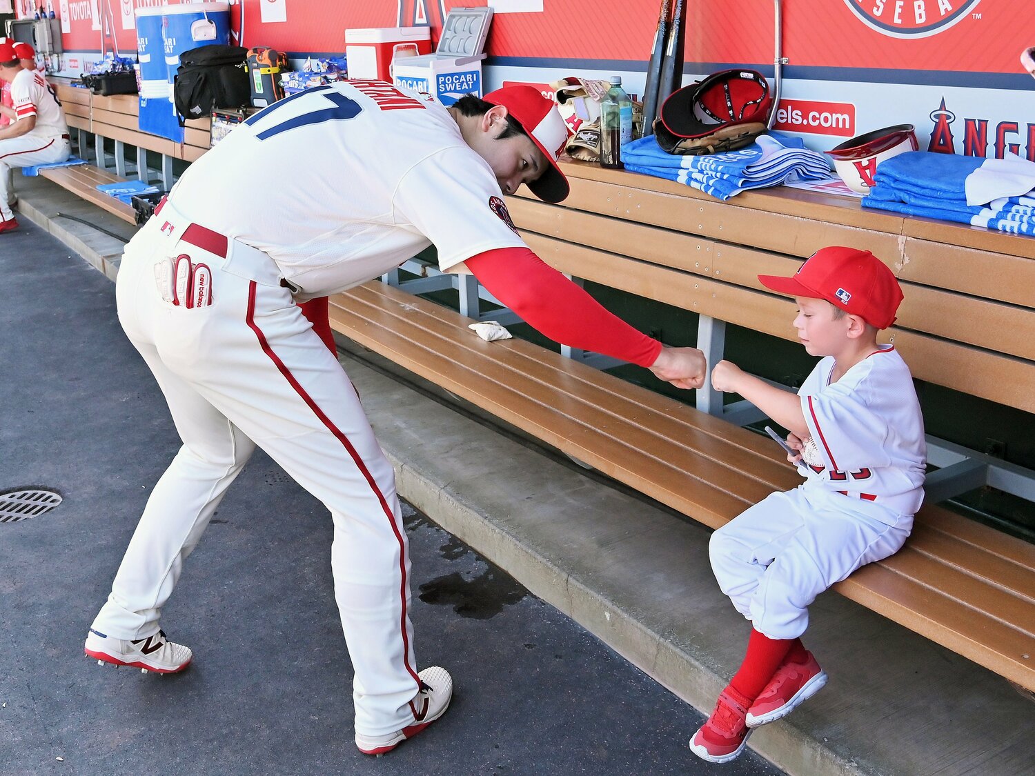 7月16日のアストロズとの試合前、ベンチの子どもにサインして拳を合わせる　©JIJI PRESS
