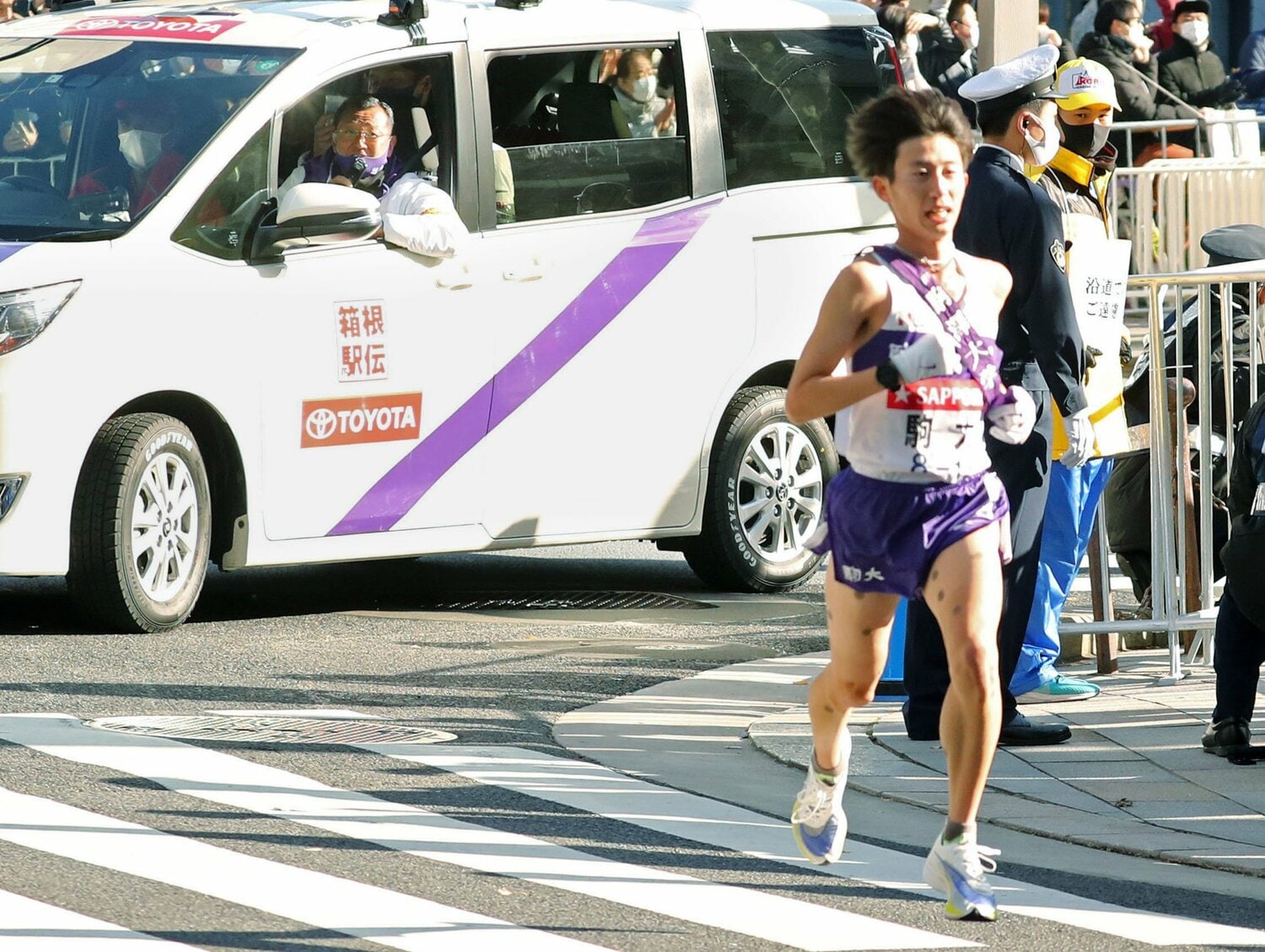 10区で力走する駒大の石川拓慎（右手前）に声を掛ける大八木弘明監督　©︎Kyodo News