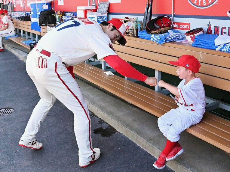 16日のアストロズとの試合前、ベンチの子どもにサインして拳を合わせる　©JIJI PRESS