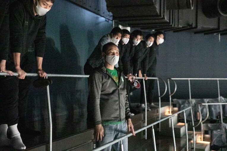 「コートから最も遠い席」からの眺めを確認する木村社長（中央）と田代（左）