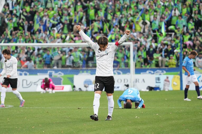 試合終了のホイッスルと同時に拳を突き上げる湘南ベルマーレのキャプテン・大岩一貴と、崩れ落ちる横浜FCの選手たち　©Etsuo Hara/Getty Images