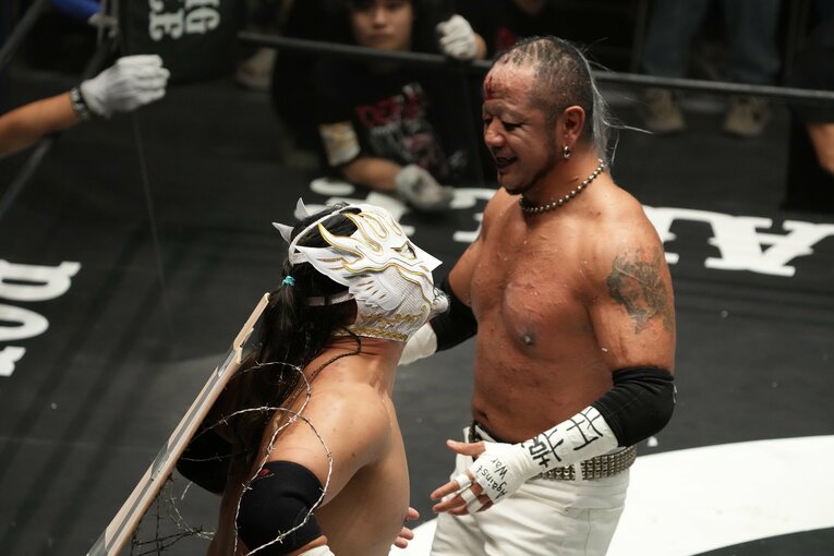 有刺鉄線ボードに押し付けられたエル・デスペラード　©Masashi Hara