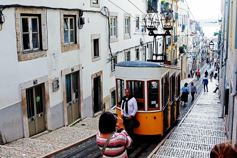 海へと繋がる急峻な坂道を路面電車が走る。懐かしさを感じさせるリスボンの街並み