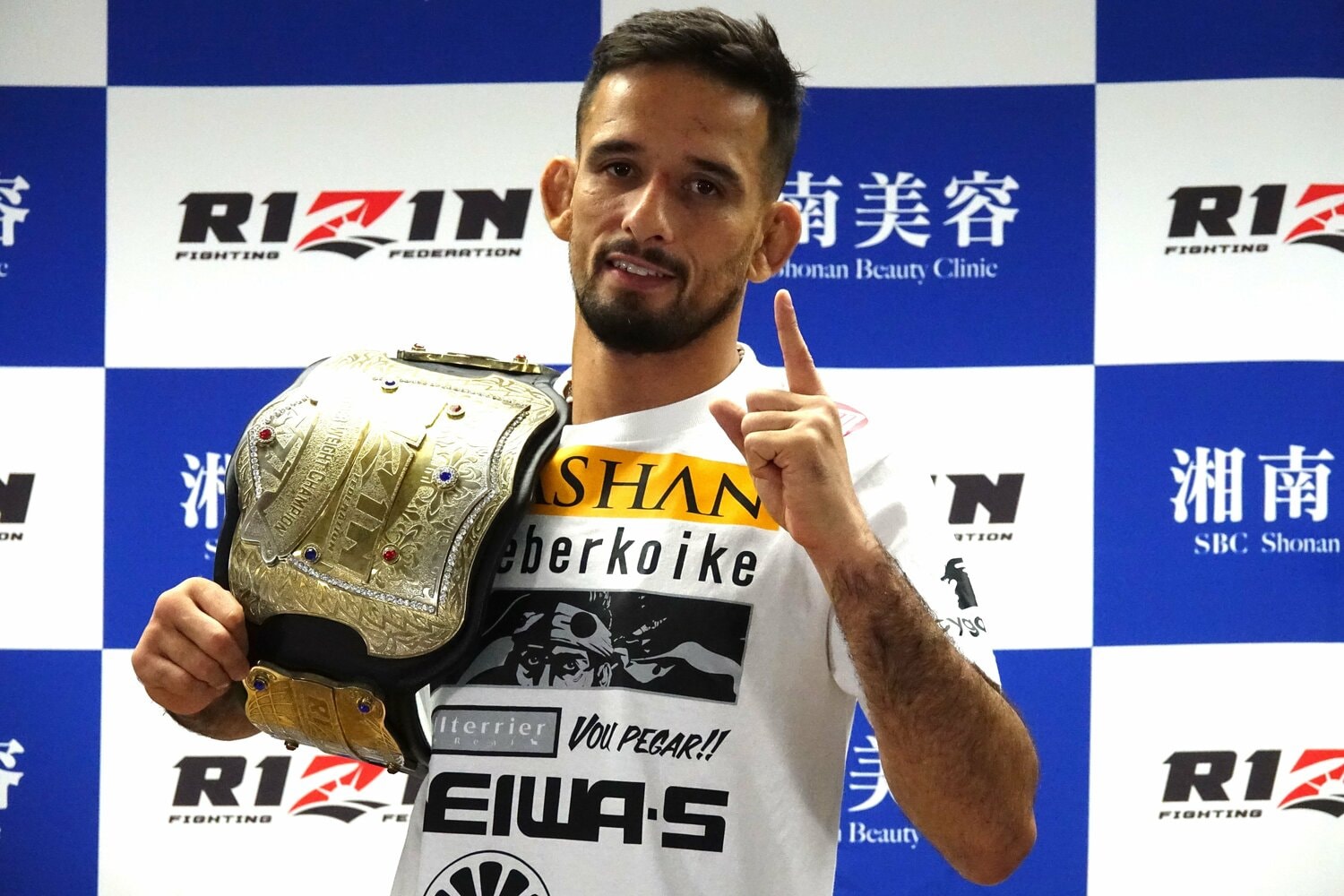 試合後の会見で誇らしげにベルトを掲げるクレベル・コイケ　©Koji Fuse