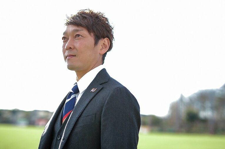 ユニホーム姿からスーツに着替え、FC東京の一員として働く羽生。引退後も、サッカーに携わり続けていく。 ／ photograph by Kiichi Matsumoto