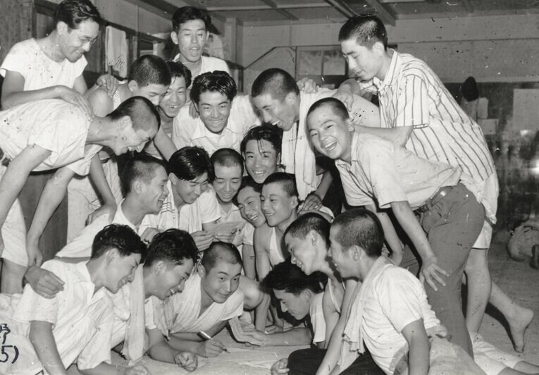 1949年、宿舎で激励の電報に喜ぶ湘南の選手たち。髪の長い生徒が複数人いるのがわかる　©Asahi Shimbun