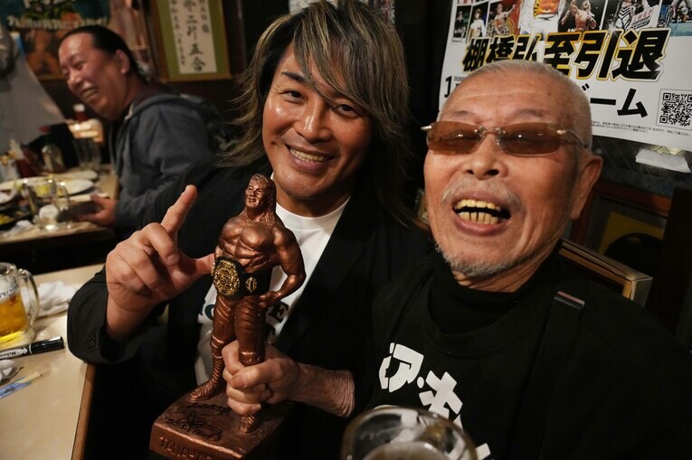 棚橋弘至ブロンズ像を手に記念写真に納まる棚橋と村田善則マスター　©Essei Hara