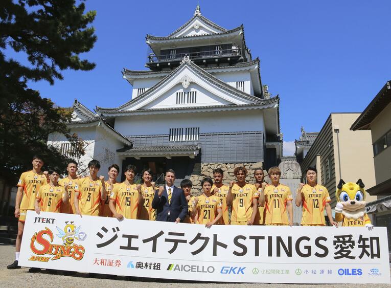 新体制を発表し、岡崎城を背にポーズをとるジェイテクトSTINGS愛知の選手たち。今季のホームユニフォームはゴールドを基調色としたデザインに変更した　©︎KYODO