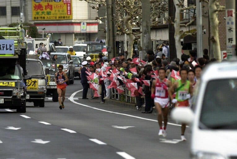 2002年箱根、往路第２区５キロすぎ、法政大学の徳本一善（左、４年）が右足を痛め途中棄権（神奈川県）　©JIJI PRESS