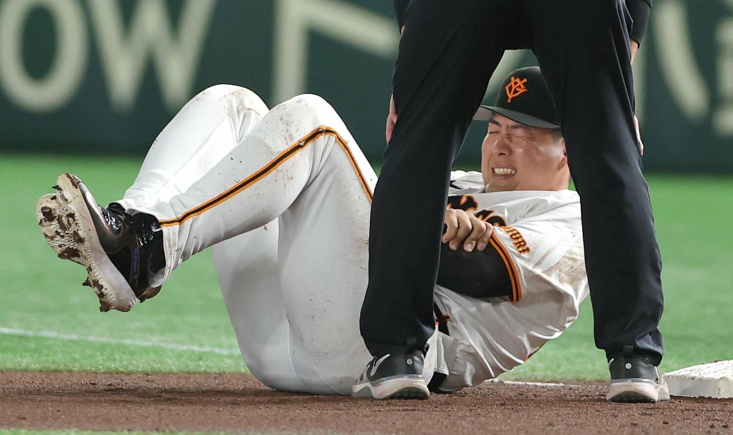 阪神戦で中野と衝突して腕を抑えて倒れる巨人のファースト岡本和真　©︎SANKEI SHIMBUN