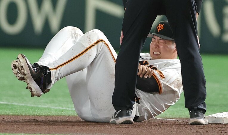 阪神戦で中野と衝突して腕を抑えて倒れる巨人のファースト岡本和真　©︎SANKEI SHIMBUN