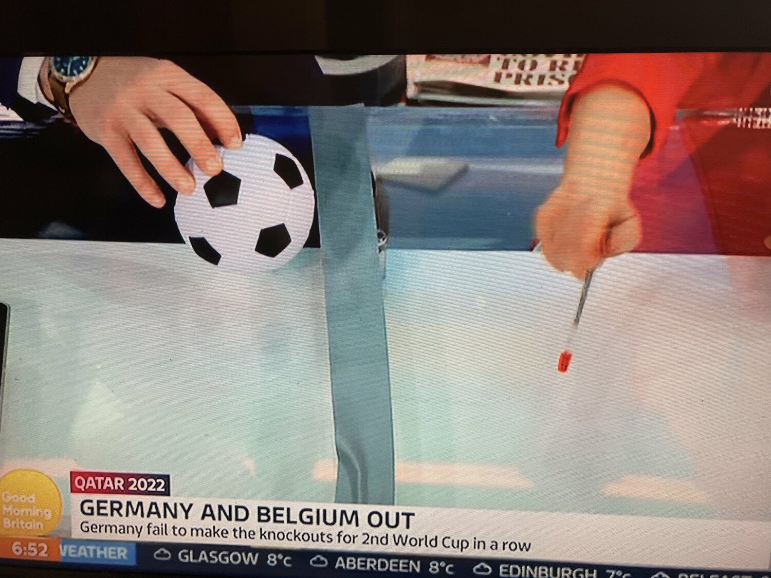 写真は英テレビ局ITVの朝の情報番組の一コマ。ガムテープをゴールラインに見立て、小さなボールで映像アングルを変えながら三笘のアシストを説明