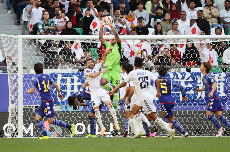 イラク選手とハイボールを競り合う鈴木　©JIJI PRESS