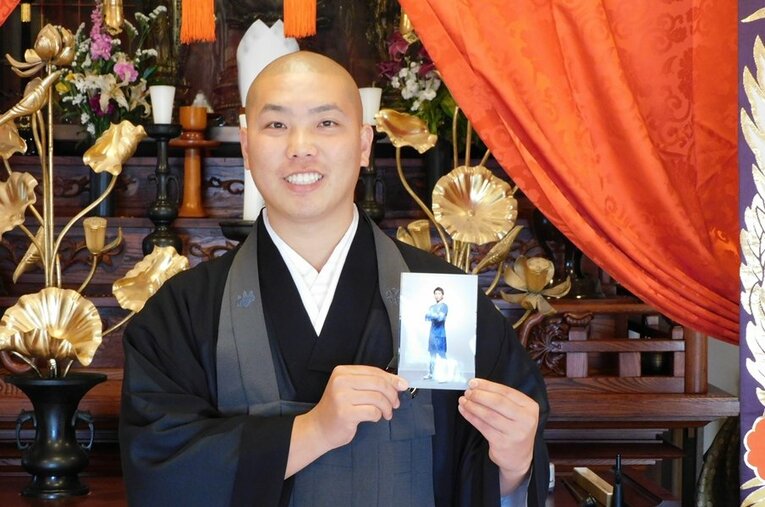 現在は静岡県の林入寺で副住職となった五藤晴貴さん。カターレ富山時代の写真を手に　©Jun Aida