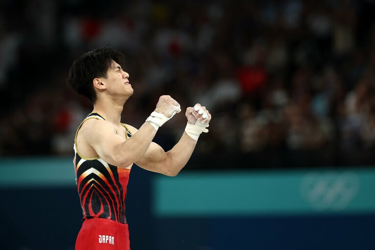 橋本が鉄棒の着地を決めると、会場はスタンディングオベーションで祝福　©Getty Images
