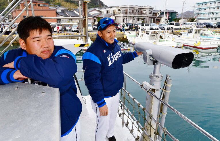 まったりと船に乗る中村剛也と栗山巧（2019年２月、日南キャンプの歓迎船上パレードで）　