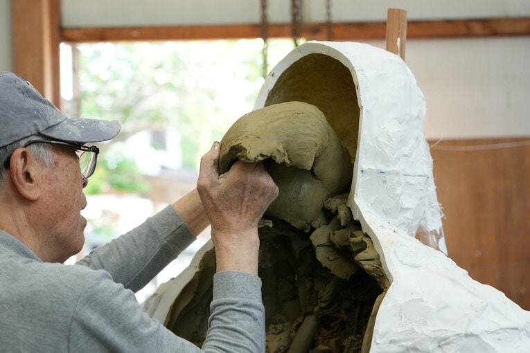 頭部から引き出される粘土の原型