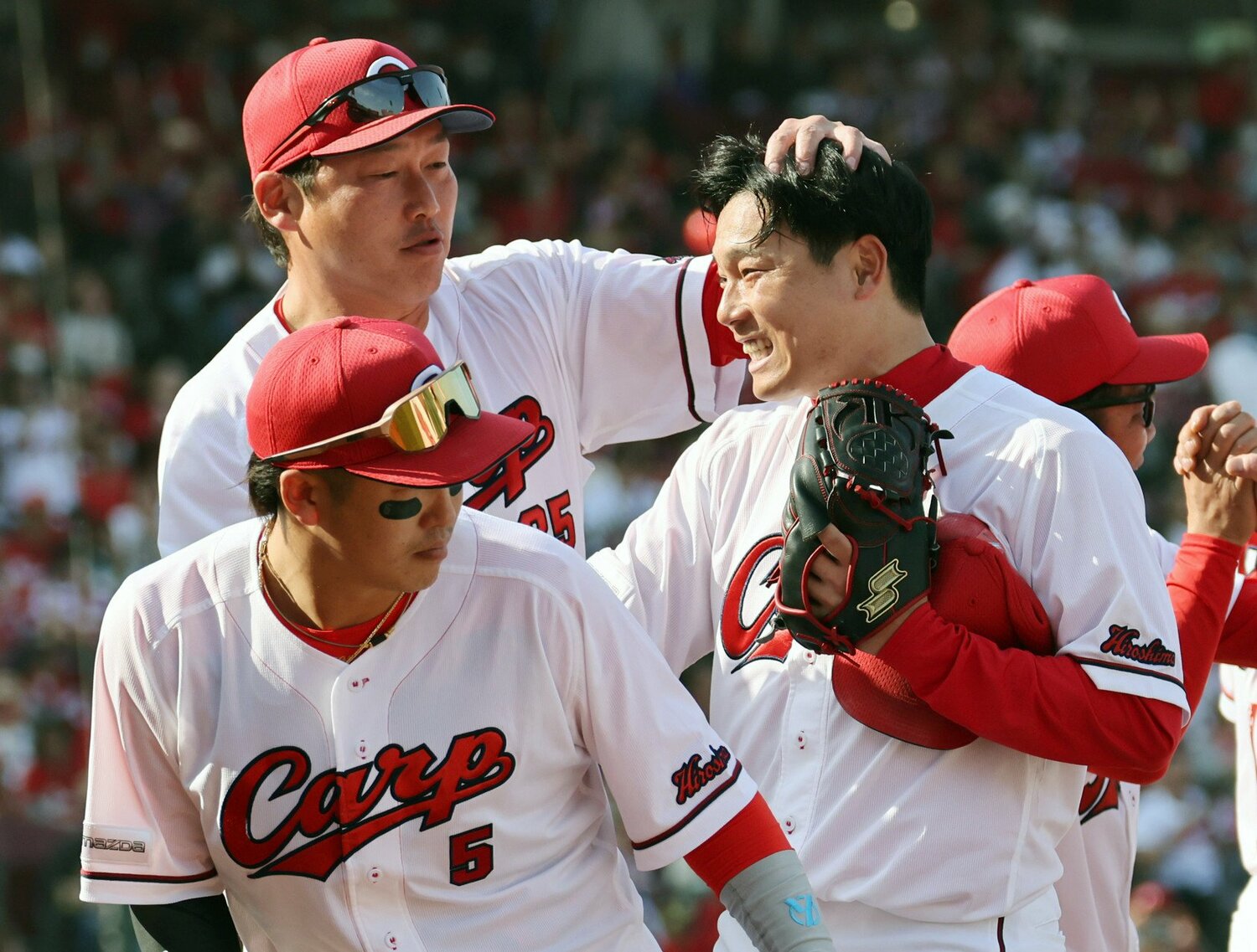 新井貴浩監督に祝福される栗林 ©JIJI PRESS