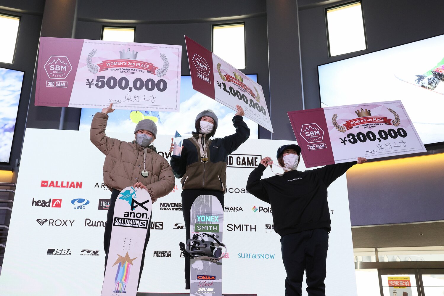 東野氏のサイン入り優勝記念ボードを手にする女子1位冨田るき、2位覚張美咲、3位黒木あかり　©Shigeki Yamamoto